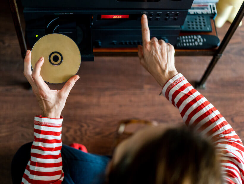 woman loading CD/DVD into player woman loading CD/DVD into player